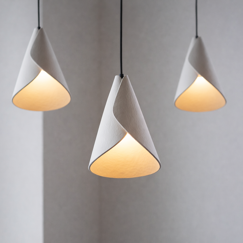 Three cone-shaped pendant lights hanging against a plain background