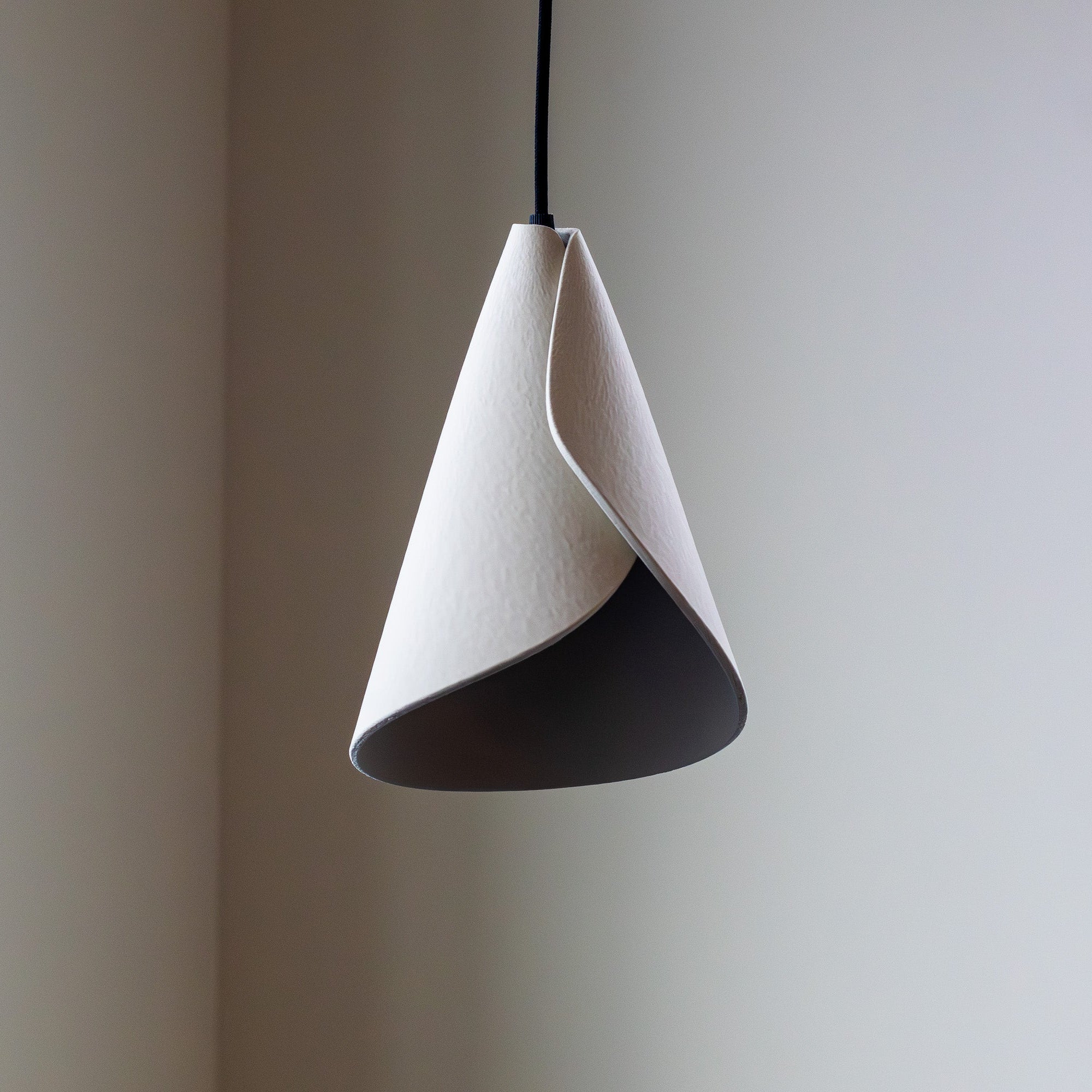 Conical pendant light with a black accent on a plain background