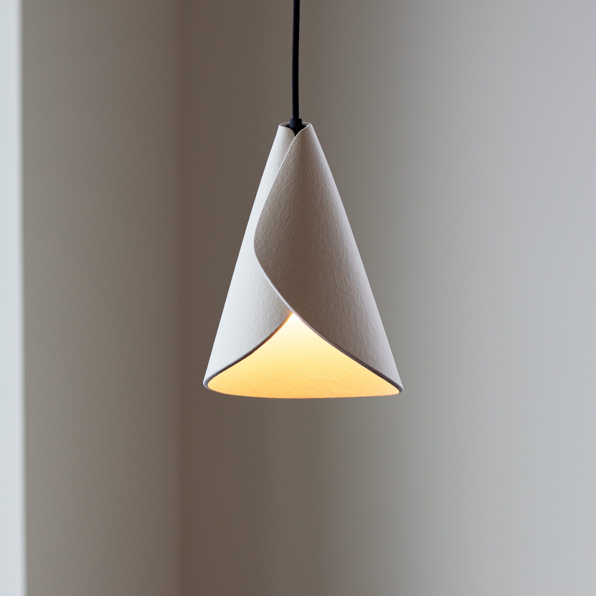 Modern pendant light with a white conical shade on a neutral background