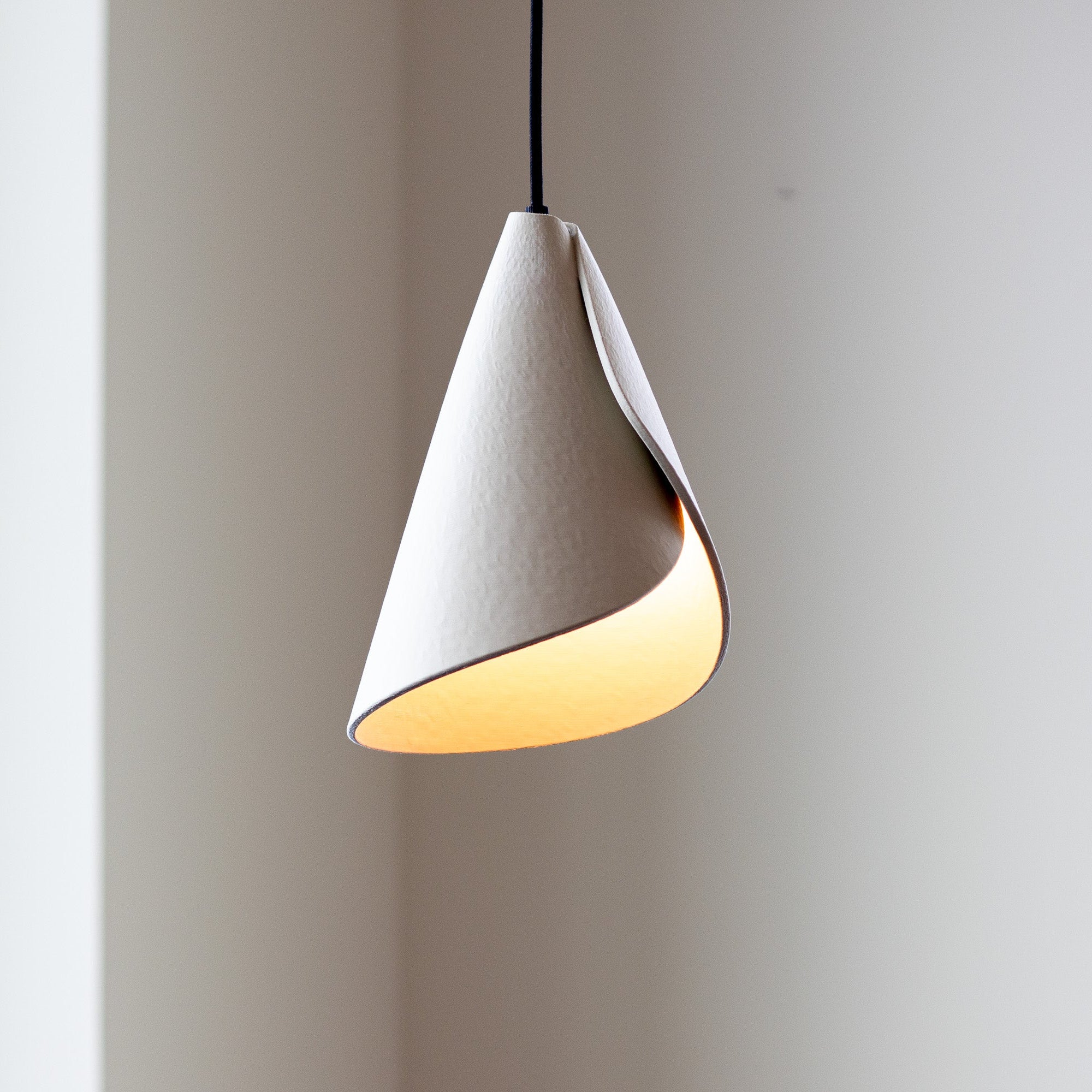 Modern pendant light with a white and gold design on a plain background